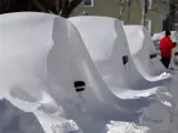 Una fila de coches aparcados, completamente cubiertos por la nieve, tras una intensa nevada en la ciudad de Boston (EE UU).