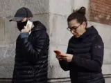 Un hombre camina con mascarilla junto a una mujer sin mascarilla en Madrid.