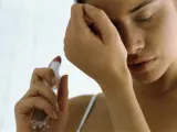Una mujer se echa y huele su perfume.