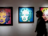Una persona para por delante de los retratos de Marilyn Monroe, en la inauguración de la exposición Andy Warhol Super Pop.