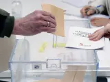 Una persona introduce su voto en la urna en un colegio de Valladolid durante las elecciones de Castilla y León.