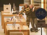 Un rehén es conducido a punta de pistola por un hombre, el presunto secuestrador, durante un robo a mano armada en una tienda de Apple de Ámsterdam, Países Bajos.
