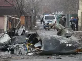 Un soldado ucraniano comprueba los restos de un avi&oacute;n derribado por una bater&iacute;a antia&eacute;rea, en Kiev (Ucrania).