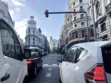 Dos taxis esperan a que un semáforo de la Gran Vía madrileña se ponga en verde.