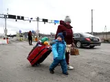 Una mujer cruza la frontera con su hijo en Medyka, en la frontera de Polonia con Ucrania