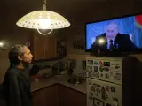 Una mujer observa desde su casa en San Petersburgo un discurso de Vlad&iacute;mir Putin.