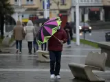 Un hombre camina bajo la lluvia con un paraguas por el paseo marítimo en A Coruña.