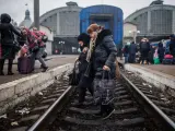 Dos mujeres cruzan las vías a 4 de marzo de 2022, en la estación de tren de Lviv (Ucrania).