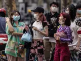 Varias personas con mascarilla caminan por la calle en Shangái, en China, este domingo.