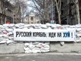 Una pancarta en Odesa pegada a un puesto de control reforzado con bloques de hormigón y sacos de arena