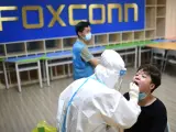 Un trabajador médico realizando una prueba de COVID en una fábrica de Foxconn en Wuhan en agosto de 2021.