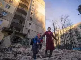 Una mujer y un niño salen de un edificio residencial bombardeado en Kiev el 16 de marzo de 2022.