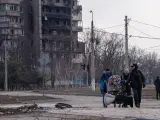 Civiles huyen con sus enseres de los ataques rusos en la ciudad ucraniana de Mariúpol.