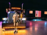 El cantante puertorriqueño Bad Bunny posa frente a su camión tráiler negro mate de 16 metros.
