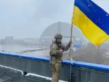 Un soldado iza la bandera de Ucrania en Chernóbil.
