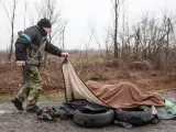 Un miembro de la defensa civil busca cad&aacute;veres en Bucha, Ucrania, tras la salida de las tropas rusas en la ciudad.