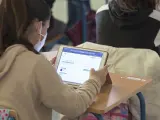Una alumna en clase ante una tableta digital