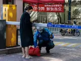 Una mujer en cuarentena recibe un pedido en una comunidad residencial bajo encierro en Shanghái, China, el 18 de abril de 2022.