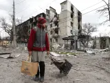 Una mujer camina entre edificios destruidos por los bombardeos en la ciudad ucraniana de Mariúpol, el 19 de abril de 2022.
