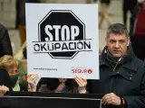 Imagen de archivo de una persona, con una pancarta que rezan 'Stop Okupación' en la concentración en apoyo a los afectados por la okupación.