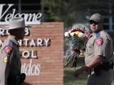 Dos agentes llevan flores a la primaria Robb en Uvalde, Texas.