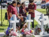 Familiares dejan flores en cruces en recuerdo a las víctimas de la matanza escolar de Texas.