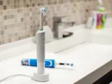 Rechargeable, electric toothbrush, close-up. Against the backdrop of a bathroom in white. Water faucet and white sink