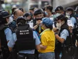 La Policía impide el paso a una mujer cerca del Parque Victoria en Hong Kong, en las inmediaciones de la plaza de Tiananmen.