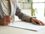 Una persona lee un documento antes de firmarlo, en una imagen de archivo.