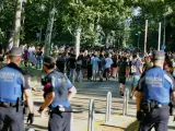 Varios policías controlan la multitud de estudiantes tras finalizar las pruebas de la EvAU en Madrid.