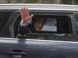El presidente francés, Emmanuel Macron, saluda desde el coche.