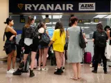 Varias personas esperan a ser atendidas por los trabajadores de Ryanair en el aeropuerto de Barcelona durante la jornada de huelga de este viernes.