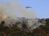 Un helicóptero lanzando agua sobre el incendio de Castell d'Aro (Girona).