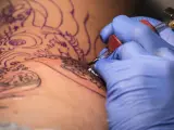 Un tatuador realiza un tatuaje, en una imagen de archivo.