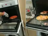Tres jóvenes, incapaces de sacar una pizza del horno.