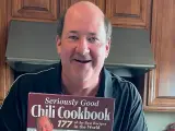 Brian Baumgartner, de 'The Office', mostrando su libro de recetas de chile.