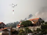 Un helicóptero participa en las labores de extinción de un incendio declarado en Meira, Moaña (Pontevedra), el 22 de agosto de 2022, y que obligó a declarar situación 2 de alerta por la cercanía a las casas.