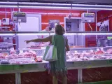 Una mujer hace la compra en la carnicería del Mercado de Pacífico, en Madrid.