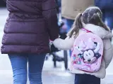 Una niña camina hacia el colegio de la mano de su madre, en una imagen de archivo.
