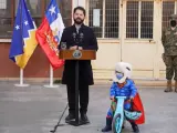Boric, presidente de Chile, interrumpido por un niño en bicicleta vestido de Superman.