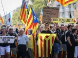 Manifestantes portando pancartas muy críticas con los políticos soberanistas en la marcha central de la Diada 2022 de Cataluña.