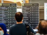 Varios pasajeros revisan la información de los vuelos en el Aeropuerto Adolfo Suárez Madrid-Barajas, en una imagen de archivo