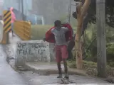 Un niño camina en medio de los fuertes vientos durante el paso del huracán Fiona, en Nagua (República Dominicana).