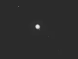 Una composición recortada de una imagen que el DART ha tomado de Júpiter y sus satélites más grandes.