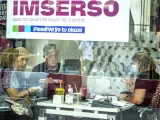 Varias personas mayores piden información en una agencia de viajes adherida al programa del Imserso.