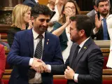 El president Aragonès (derecha) y el vicepresident Jordi Puigneró (Junts) dándose la mano tras la aprobación de la ley del catalán en el Parlament.