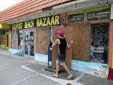 Un hombre protege su negocio en Gulfport Beach, Florida (EE UU), ante la llegada del huracán Ian.