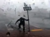 En una conexión en directo de la cadena The Weather Channel, el reportero trata de medir la velocidad del aire, cuando apenas puede moverse para resistir la potencia de las rachas de viento del huracán Ian, y tiene que agarrarse al poste de una señal de tráfico, en Punta Gorda, Florida (EE UU).