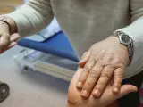 Las manos de un cuidador con una persona mayor