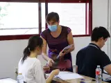 Una profesora entrega exámenes a una alumna durante la realización de las pruebas de acceso a la universidad 2022, a 8 de junio de 2022, en Valladolid, Castilla y León (España).